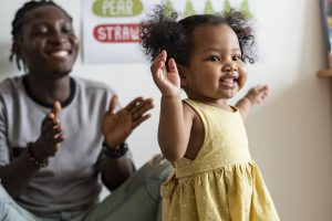 Happy girl and teacher having fun in nursery